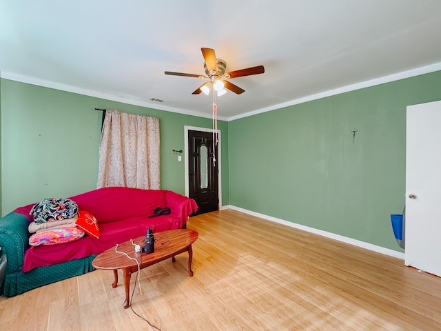 living room with hardwood / wood-style floors, ceiling fan, and ornamental molding