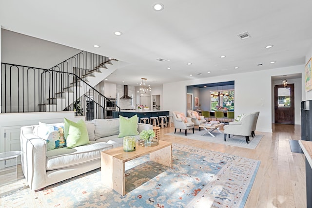 living room with an inviting chandelier and light hardwood / wood-style flooring