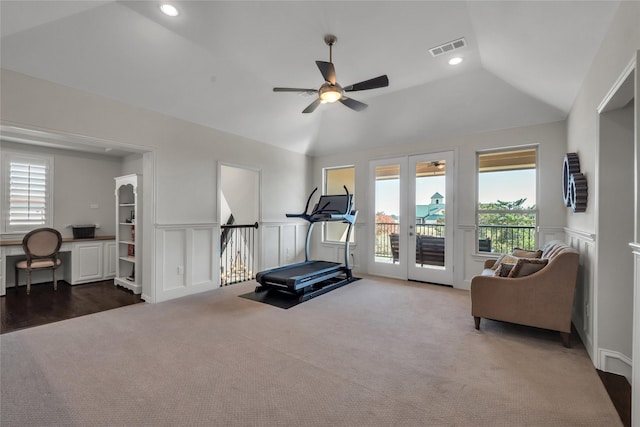 exercise area with dark colored carpet, vaulted ceiling, and ceiling fan