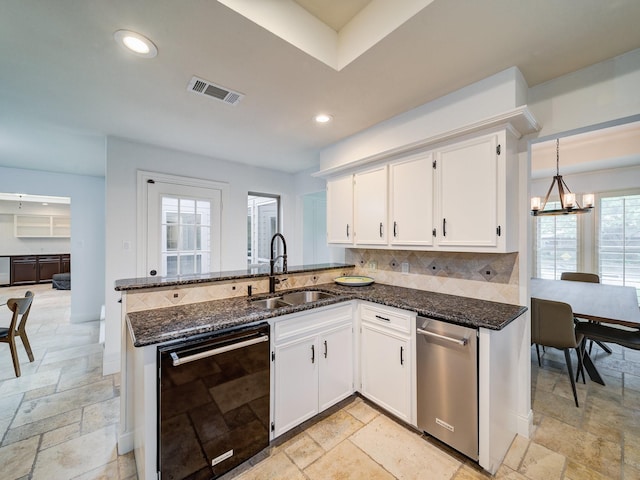 kitchen featuring dishwasher, sink, kitchen peninsula, a chandelier, and white cabinets