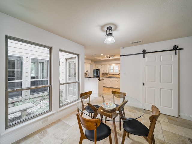 dining space featuring a barn door and sink