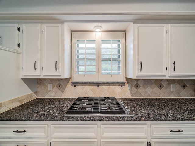 kitchen with white cabinets, decorative backsplash, and stainless steel gas stovetop