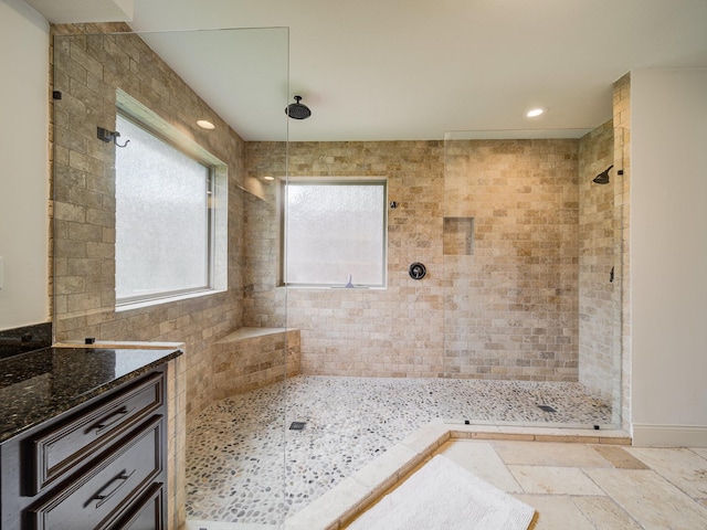 bathroom with vanity and a tile shower