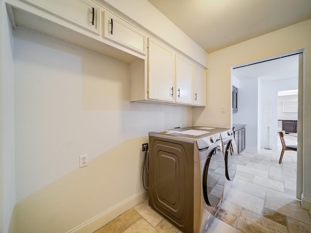 clothes washing area featuring cabinets and washing machine and dryer