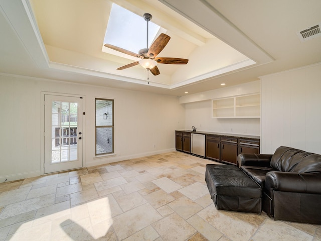 living room featuring a tray ceiling, ceiling fan, crown molding, and lofted ceiling