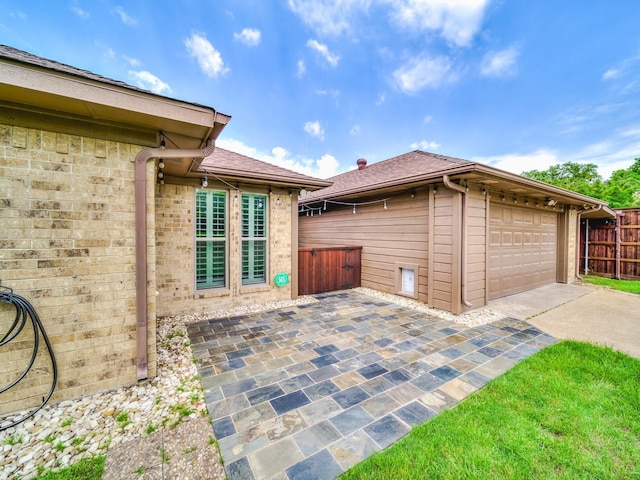 view of patio / terrace featuring a garage and an outbuilding