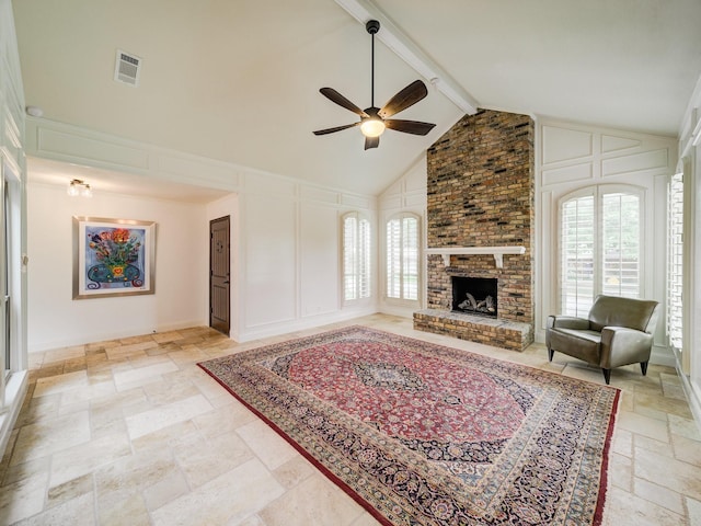 living room featuring ceiling fan, beamed ceiling, high vaulted ceiling, and a brick fireplace