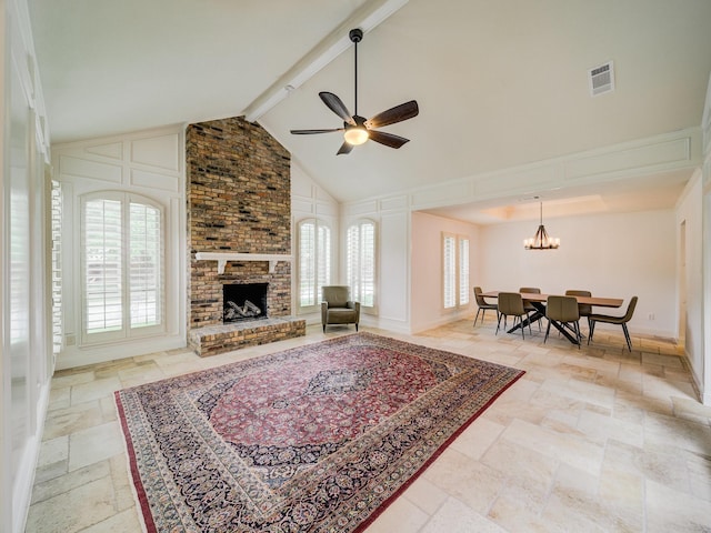 living room featuring beamed ceiling, high vaulted ceiling, ceiling fan with notable chandelier, and a brick fireplace