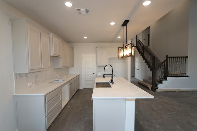 kitchen featuring recessed lighting, light countertops, a center island with sink, and hanging light fixtures