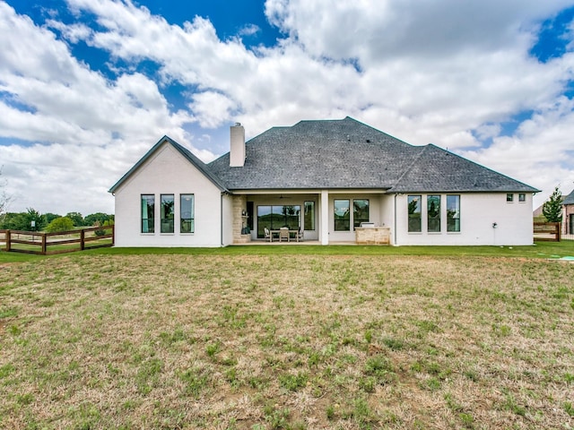 rear view of property featuring a yard and ceiling fan