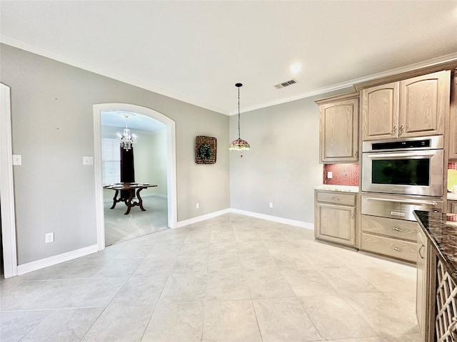 kitchen with light brown cabinetry, backsplash, crown molding, oven, and hanging light fixtures