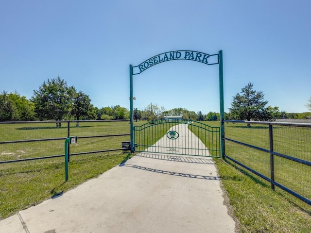 view of gate with a lawn