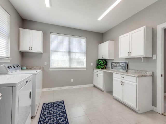 clothes washing area featuring cabinets, light tile patterned floors, and washer and dryer