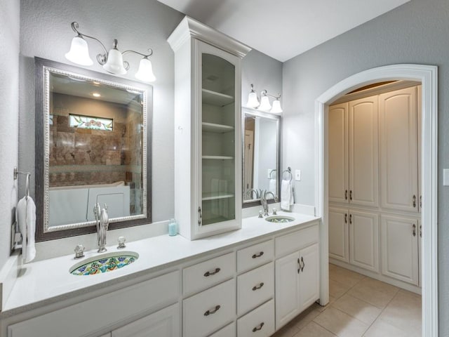 bathroom with tile patterned floors, a shower, and vanity