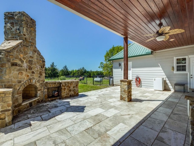 view of patio / terrace featuring an outdoor stone fireplace and ceiling fan