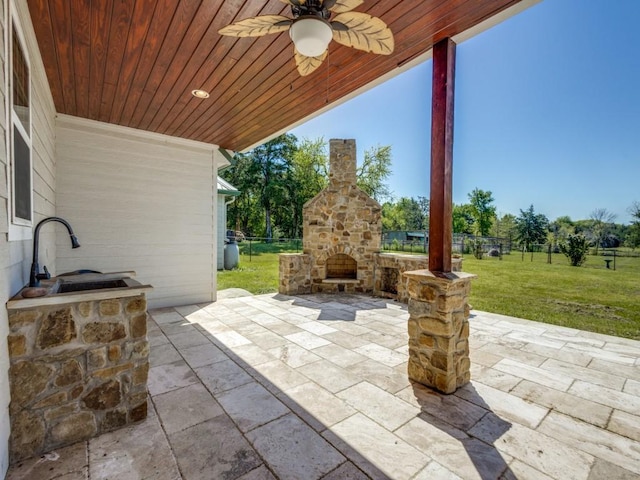 view of patio / terrace with ceiling fan and an outdoor stone fireplace