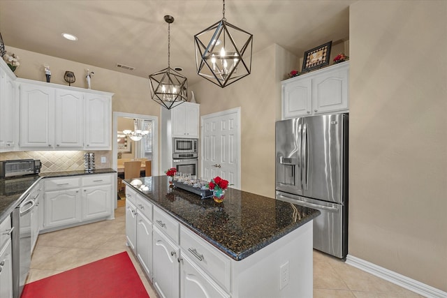 kitchen with hanging light fixtures, stainless steel appliances, a center island, and white cabinets