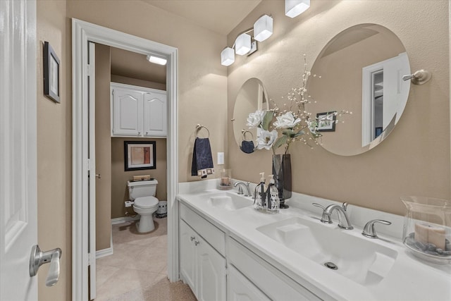 bathroom with vanity, tile patterned floors, and toilet