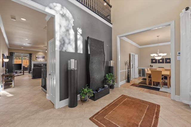 entryway featuring light tile patterned flooring, a notable chandelier, and crown molding