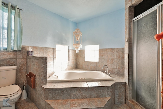 bathroom featuring plus walk in shower, tile patterned flooring, toilet, and tile walls