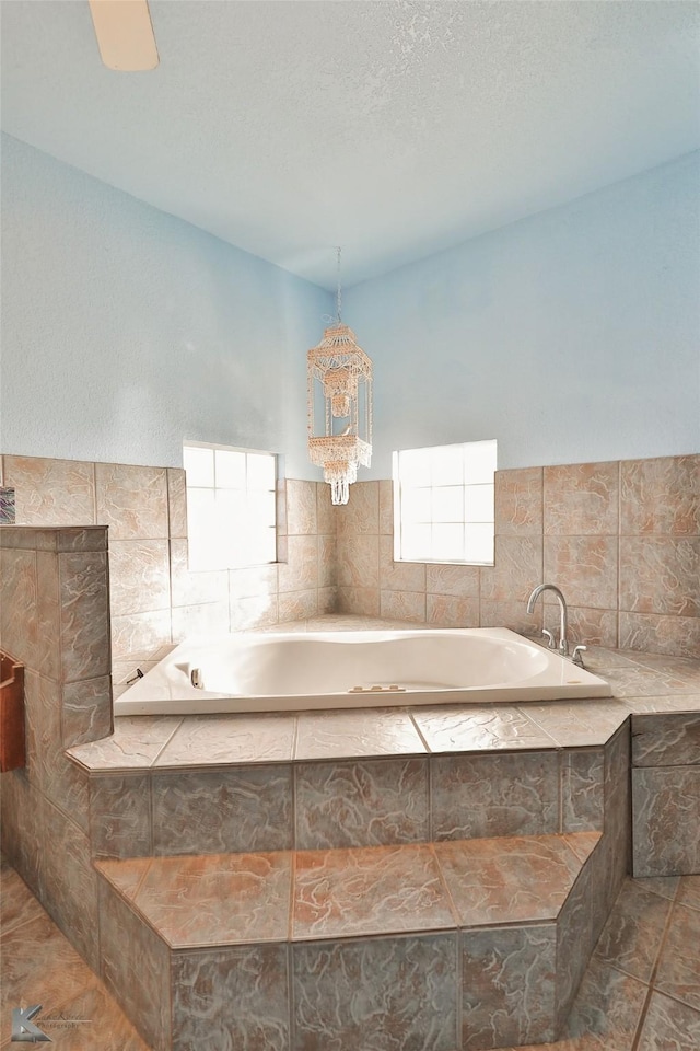 bathroom with tile patterned flooring and tiled bath