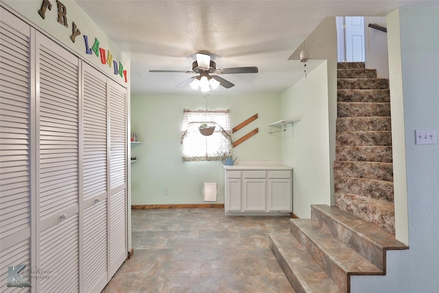 interior space with ceiling fan and a textured ceiling