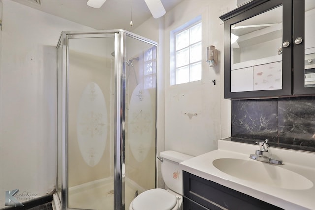 bathroom with tasteful backsplash, vanity, toilet, and a shower with shower door