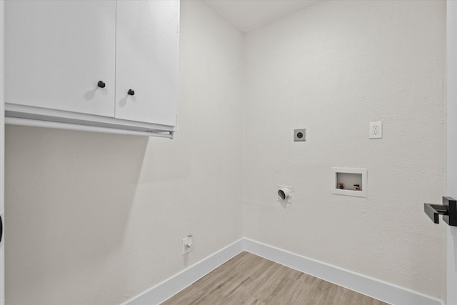 washroom with washer hookup, light hardwood / wood-style flooring, cabinets, and hookup for an electric dryer