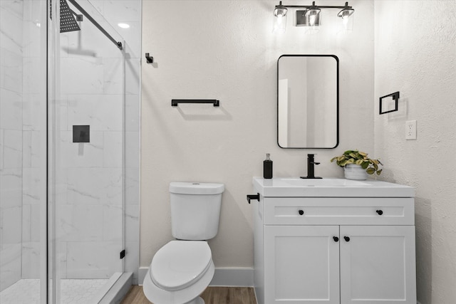 bathroom featuring toilet, vanity, an enclosed shower, and hardwood / wood-style flooring