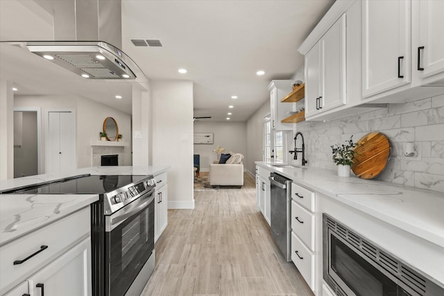 kitchen featuring white cabinets, light wood-type flooring, sink, and appliances with stainless steel finishes