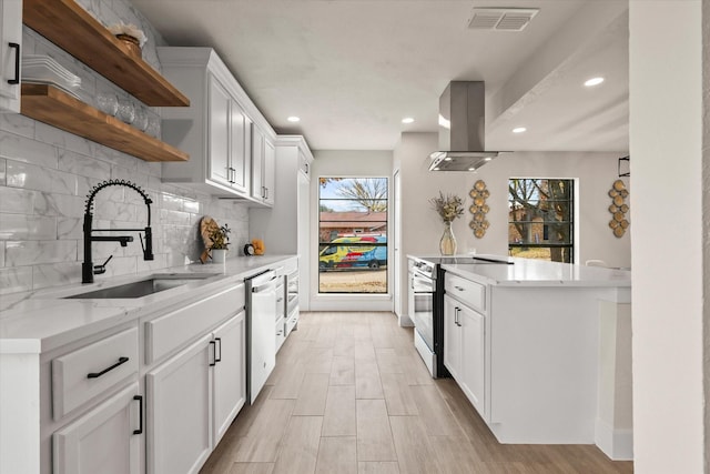 kitchen featuring electric range, dishwasher, sink, island exhaust hood, and white cabinets