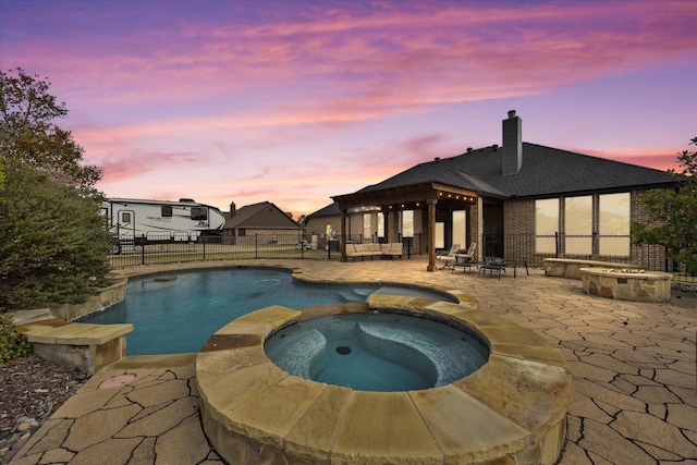 pool at dusk with a gazebo, a patio, and an in ground hot tub