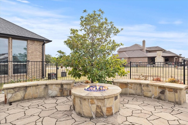 view of patio featuring an outdoor fire pit and fence