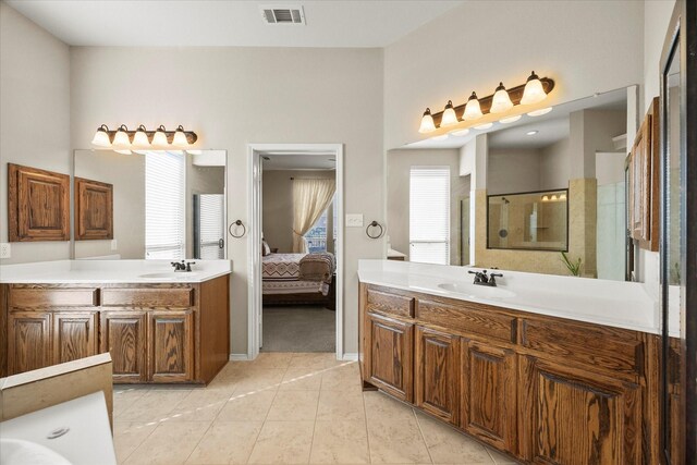 bathroom with an enclosed shower, vanity, and tile patterned flooring