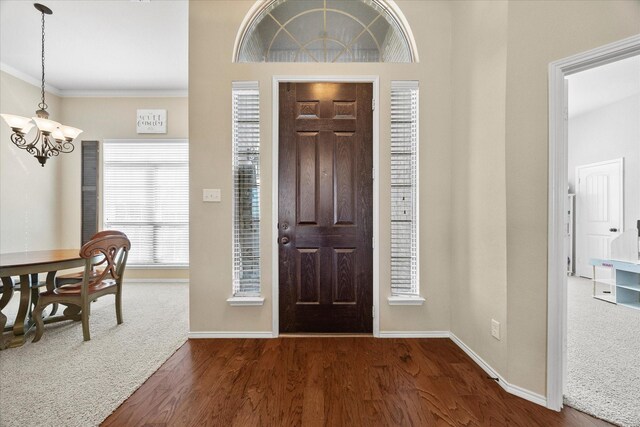 entrance foyer featuring crown molding, dark hardwood / wood-style floors, and a notable chandelier