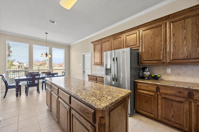 kitchen featuring stainless steel refrigerator with ice dispenser, a center island, light tile patterned floors, ornamental molding, and a notable chandelier