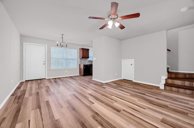 unfurnished living room featuring ceiling fan with notable chandelier and light hardwood / wood-style floors