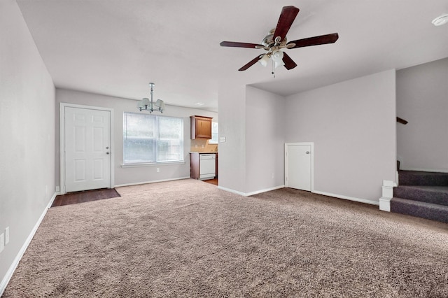 unfurnished living room featuring dark carpet and ceiling fan with notable chandelier