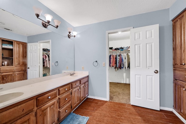 bathroom with hardwood / wood-style floors, vanity, and a textured ceiling