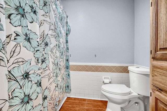 bathroom with tile patterned floors, toilet, and tile walls