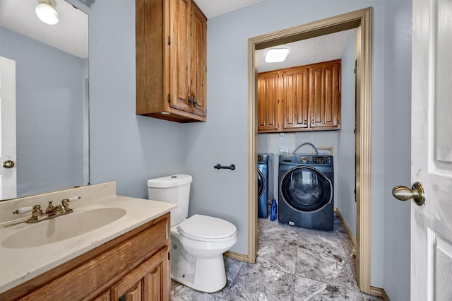 bathroom with vanity, a textured ceiling, washing machine and dryer, and toilet