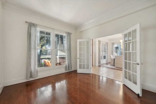 spare room featuring wood-type flooring, ornamental molding, french doors, and a healthy amount of sunlight