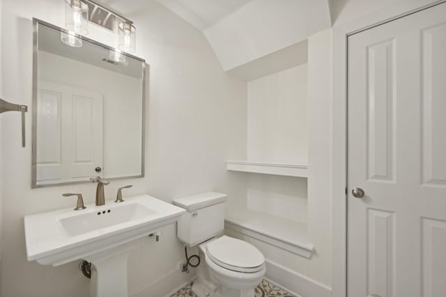 bathroom with tile patterned floors, toilet, sink, and vaulted ceiling