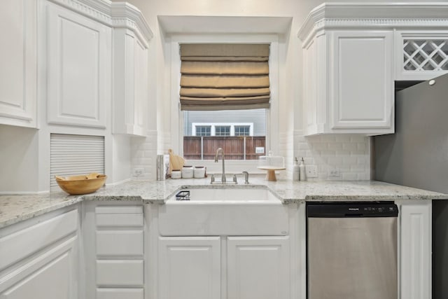 kitchen with decorative backsplash, white cabinetry, sink, and stainless steel dishwasher