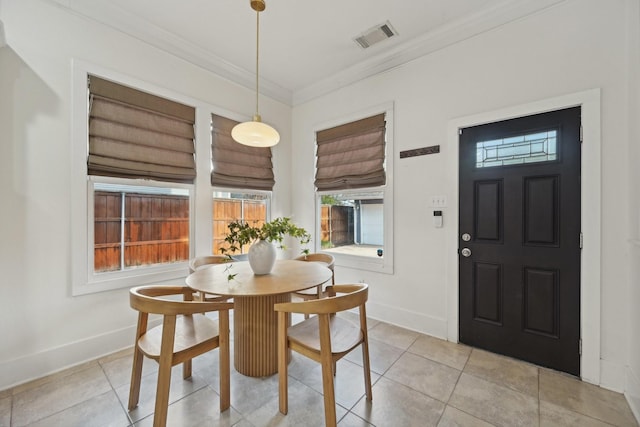 tiled dining space featuring crown molding