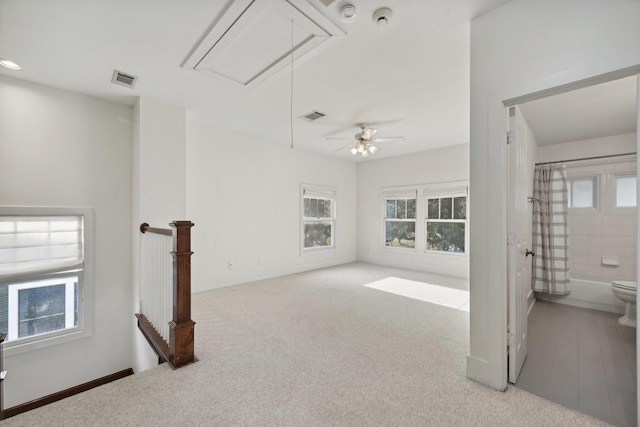 carpeted empty room with a wealth of natural light and ceiling fan