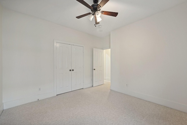 unfurnished bedroom featuring a closet, ceiling fan, and light colored carpet