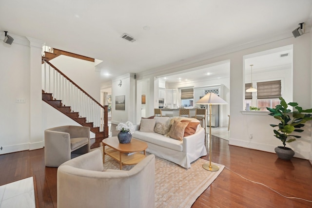 living room with hardwood / wood-style flooring and ornamental molding