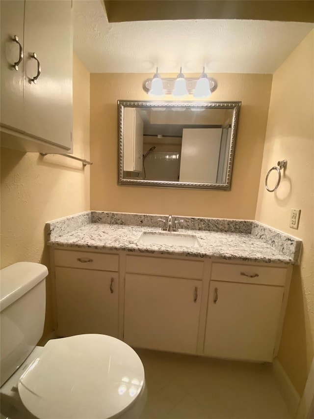 bathroom featuring vanity, toilet, and a textured ceiling