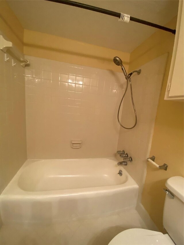 bathroom featuring tiled shower / bath and toilet